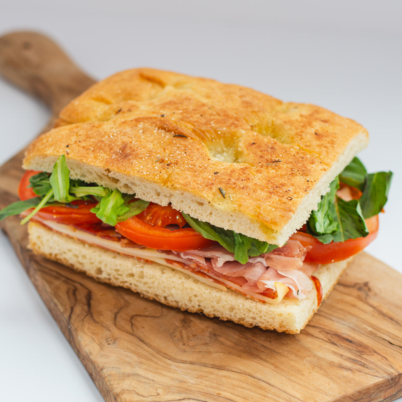 Crudo Sandwiches Fresh Italian-Style Cold Sandwiches. Layered with cured meats, cheese, tomato, greens, and house-made focaccia, our crudo sandwiches are fresh, balanced, and full of Italian-inspired flavor.